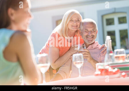 Älteres paar lächelnd und Weintrinken auf sonnigen Terrasse Stockfoto