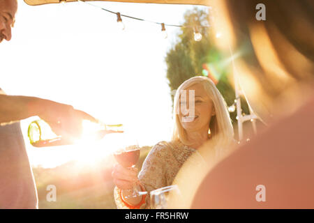 Senior woman Gießen Wein für Frau auf der sonnigen Terrasse Stockfoto