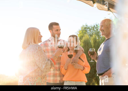 Familie sprechen und trinken Wein auf der sonnigen Terrasse Stockfoto