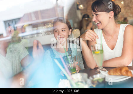 Familie Lachen am Café-Tisch Stockfoto