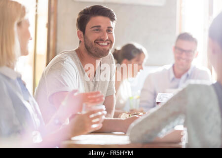 Lächelnder Mann mit Freunden im café Stockfoto