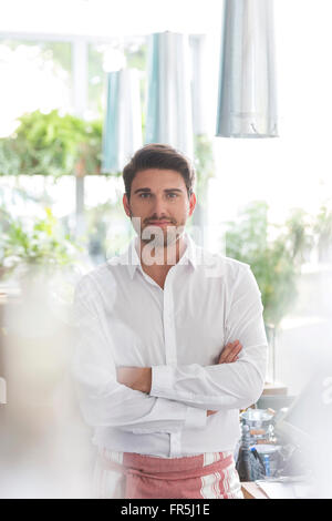 Porträt zuversichtlich Kellner mit verschränkten im café Stockfoto