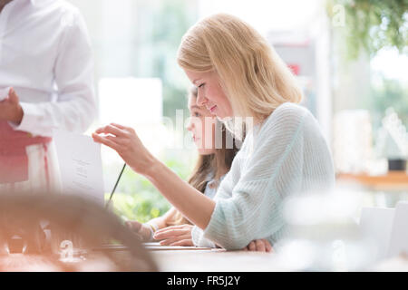 Frau liest Menü im Café-Tisch Stockfoto