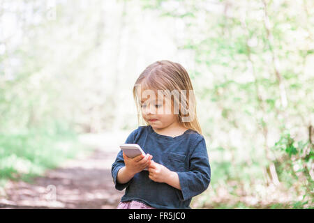 Kleinkind Mädchen mit Handy im park Stockfoto