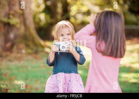 Kleinkind Mädchen spielen mit Kamera im park Stockfoto