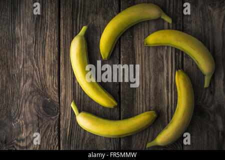Grüne Bananen auf einem alten Holztisch horizontale Stockfoto