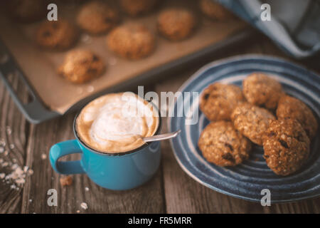 Backblech legen und einen Teller mit Haferflocken Cookies auf dem Holztisch horizontale Stockfoto