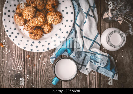 Krug, Lavendel, Haferflocken Cookies und eine Tasse Milch auf alten Brettern horizontal Stockfoto