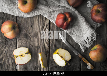 Rote Äpfel und Apfel-Hälften auf einem Holztisch horizontale Stockfoto