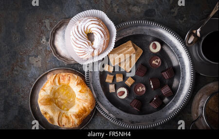 Süßigkeiten, Kuchen und Kaffee auf einem horizontalen grauen Stein Stockfoto