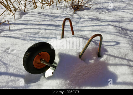 Schubkarre im Schnee, Finnland Stockfoto