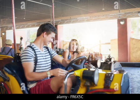 Junges Paar Reiten Autoscooter im Freizeitpark Stockfoto