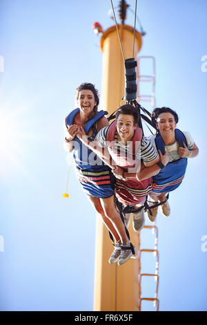 Porträt, Lächeln Freunde Bungee-Jumping im Freizeitpark Stockfoto