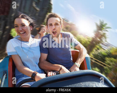 Begeisterte junge Paar schreien auf Vergnügungspark fahren Stockfoto