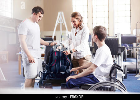 Physiotherapeuten mit Mann im Rollstuhl Stockfoto