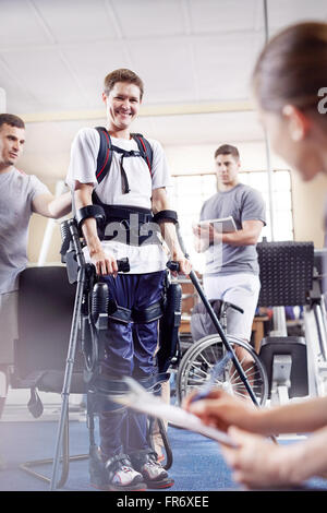 Lächelnder Mann mit Unterarm Krücken in der physikalischen Therapie Stockfoto