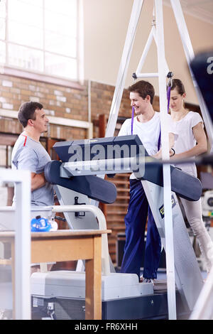 Physiotherapeuten helfen Mann auf Laufband Stockfoto