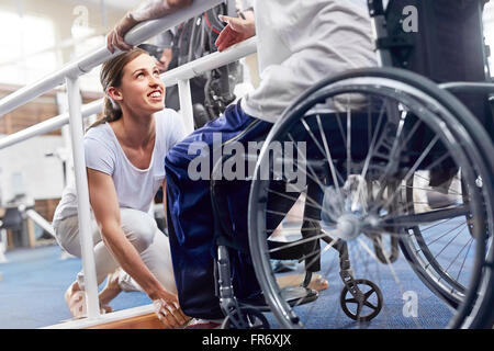 Physiotherapeuten, die Vorbereitung der Mann im Rollstuhl Stockfoto