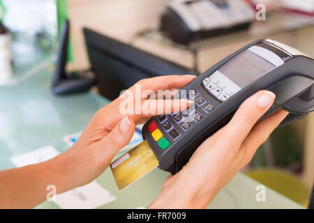 Closeup Händen Frau mit Kreditkarte Swipe über Terminal für den Verkauf im shop Stockfoto