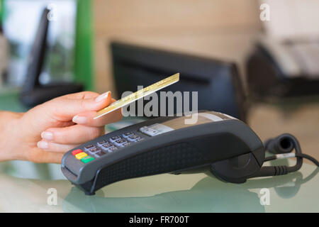 Frau mit NFC-Technologie auf Kreditkarte im Shop bezahlen. Kontaktloses bezahlen Stockfoto