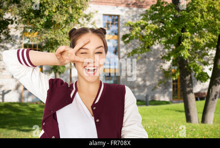 Glücklich lächelnde Jugendmädchen zeigt Frieden Zeichen Stockfoto