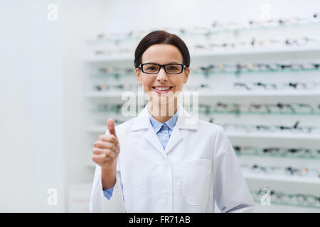 Frau in Gläsern mit Daumen hoch bei Optik Shop Stockfoto