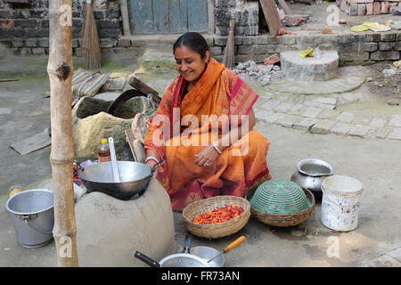 Traditionelle Art der Zubereitung von Essen am offenen Feuer in der alten Küche in einem Dorf, Kumrokhali, Westbengalen, Indien Stockfoto