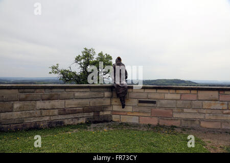 Mönch Maurus mit einer Geige, sitzen auf der Mauer um die Kirche in Pfarrkirche St. Jakob in Hohenberg, Deutschland Stockfoto