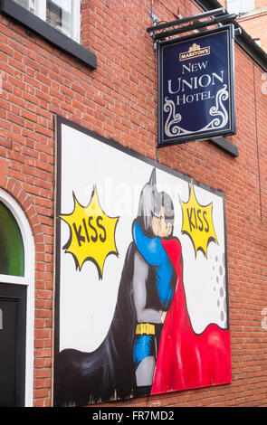 Wandbild von Batman und Robin küssen an Wand des New Union Hotel an der Canal Street in Manchesters Gay Village. Manchester. UK Stockfoto