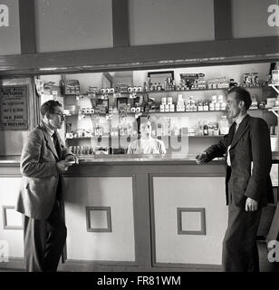 1950er Jahre historische. zwei lokale Männer Chat in der Bar des Kulturhauses, Clune, Irland. Stockfoto