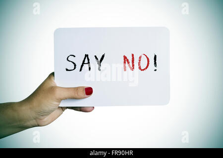 Nahaufnahme der Hand einer jungen Frau mit rot lackierten Nägeln hält ein Schild mit dem Text sagen Nein Stockfoto