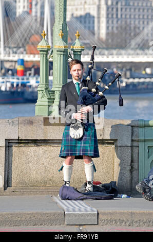 London, England, Vereinigtes Königreich. Straßenmusiker spielen Dudelsack auf Westminster Bridge Stockfoto