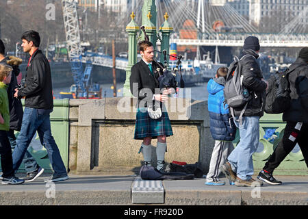 London, England, Vereinigtes Königreich. Straßenmusiker spielen Dudelsack auf Westminster Bridge Stockfoto