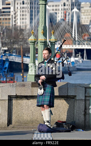 London, England, Vereinigtes Königreich. Straßenmusiker spielen Dudelsack auf Westminster Bridge Stockfoto