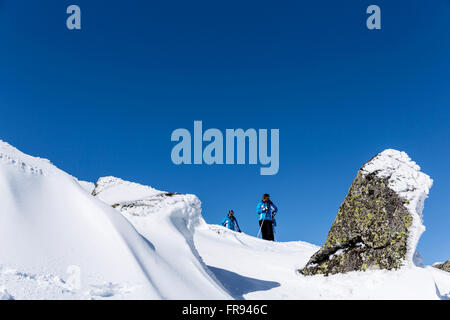 Sofia, Bulgarien - 12. März 2016: Zwei Trittbrettfahrer sind prepairing für Skifahren auf einem verschneiten felsige Berggipfel. Während eine helle Sonne Stockfoto