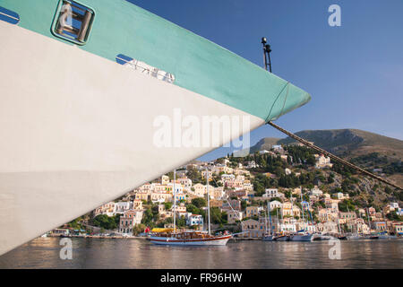 Gialos, Symi, südliche Ägäis, Griechenland. Blick über den Hafen, Bug des Kreuzfahrtschiffes im Vordergrund. Stockfoto