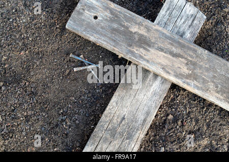 Hölzerne Kreuz Verlegung auf dem Boden mit drei Nägel in der Nähe Stockfoto