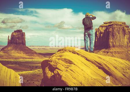 Kaukasische Naturfotograf in Denkmäler Valley Arizona, USA. Fotograf mit Rucksack Natur fotografieren. Stockfoto