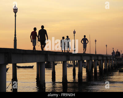 Touristen zu Fuß am späten Nachmittag auf dem Pier von Manguinhos Strand in Armacao Dos Búzios Stockfoto