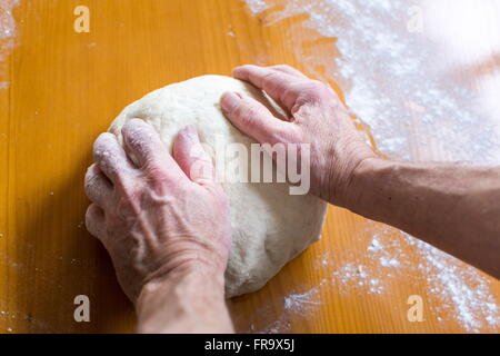 Hände eines männlichen Bäckers, die Herstellung von Brot auf dem Tisch Stockfoto