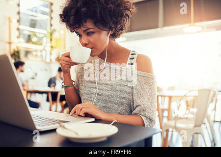 Porträt des jungen Afrikanerin Kaffee trinken und mit Laptop in einem Café. Stockfoto