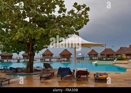 Insel Moorea, Französisch-Polynesien. Pool-Bereich und über dem Wasser Bungalow Zimmer von Moorea Pearl Resort. Stockfoto