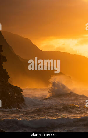 Surf-Breaks an der Na Pali Küste bei Sonnenuntergang; Kauai, Hawaii, Vereinigte Staaten von Amerika Stockfoto