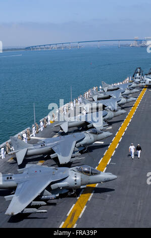 Matrosen und Marinesoldaten an Bord der USS Peleliu (LHA-5) "die Schienen auf dem Flugdeck als das Schiff Mann" Hafen verlässt Stockfoto