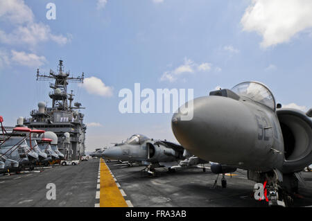 Die Nase von einer AV-8 b Marine Harrier II ragt unter anderen Rohrweihe und eine Reihe von CH-46 Sea Knight Hubschrauber an Bord der USS Peleliu (LHA-5) Stockfoto