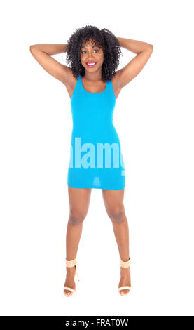 Eine schöne afroamerikanische Frau stehend von vorne in einem blauen Kleid mit den Händen hinter dem Kopf, isoliert, weiß BA Stockfoto