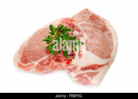 Roh-Schweinekoteletts mit Petersilie über weiß Stockfoto