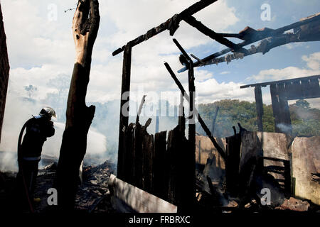 Feuerwehrmann, Feuer im Holzhaus verbrannt Außerbetriebnahme Stockfoto