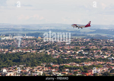 Flugzeug fliegen über die Stadt nähert sich zur Landung auf dem Flughafen Stockfoto