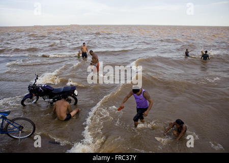 Mann Waschen der Fahrrad und Menschen Baden im Amazonas - Rampe Santa Ines Stockfoto